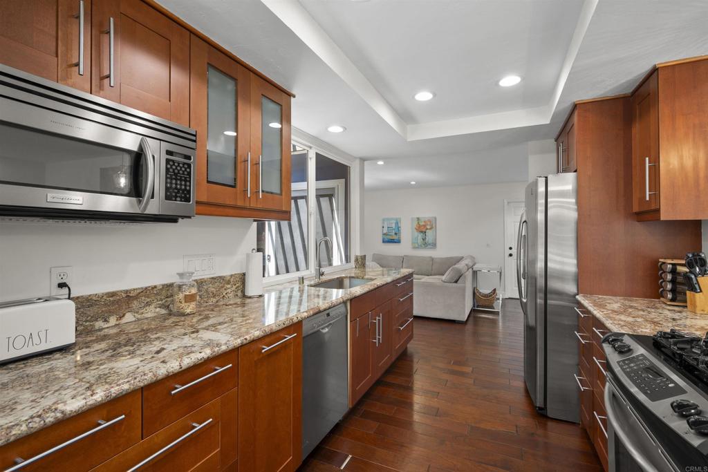 3099 Driscoll Drive San Diego, CA 92117 - Photo 20 of 41 a kitchen with stainless steel appliances granite countertop a sink and stove top oven
