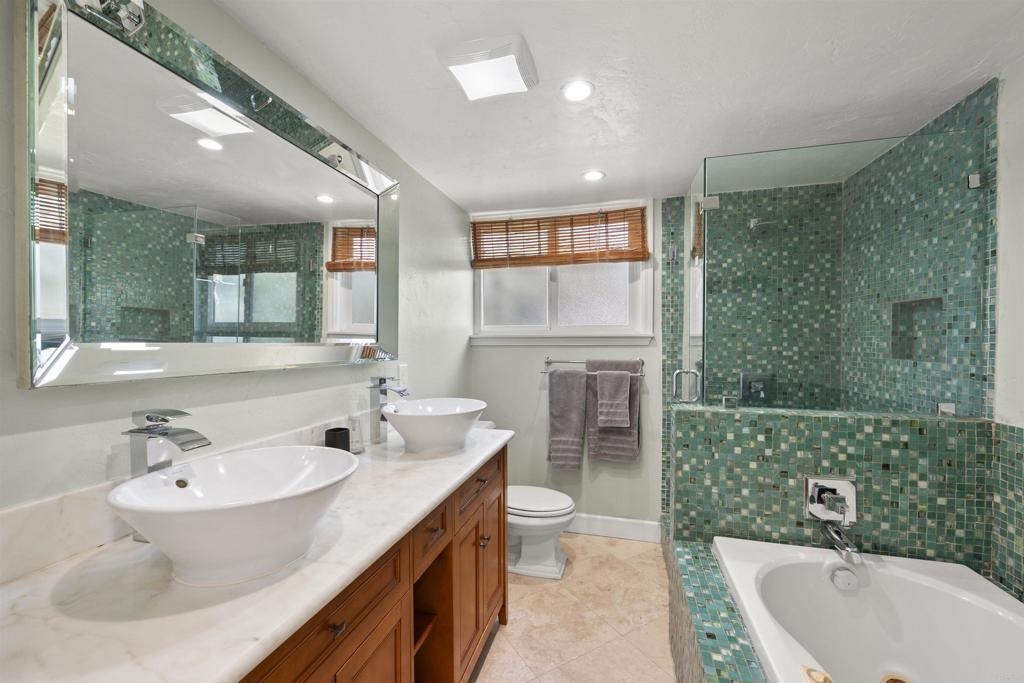 3099 Driscoll Drive San Diego, CA 92117 - Photo 27 of 41 a bathroom with a bathtub shower sink mirror and toilet
