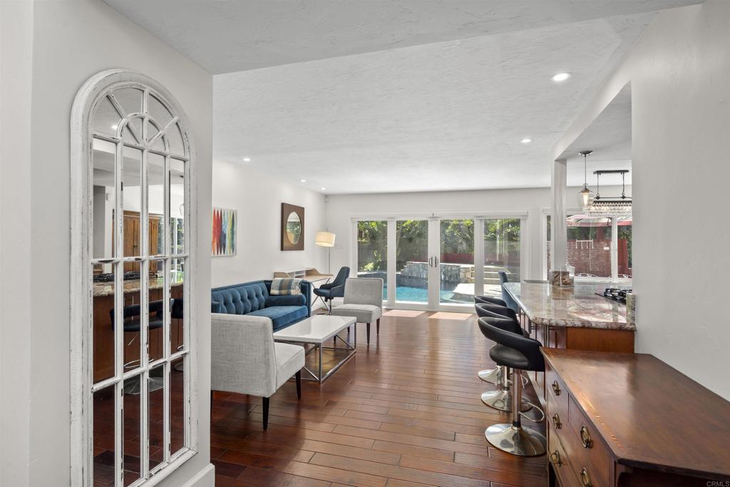 3099 Driscoll Drive San Diego, CA 92117 - Photo 7 of 41 a living room with furniture a large window and wooden floor