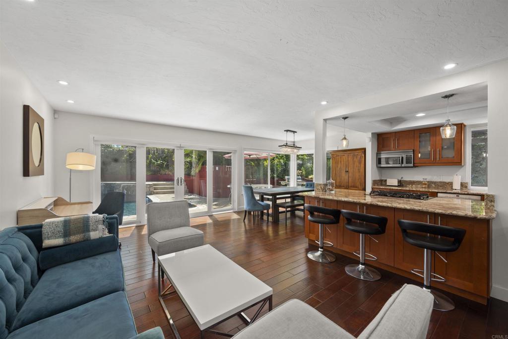 3099 Driscoll Drive San Diego, CA 92117 - Photo 10 of 41 a living room with furniture a rug and a view of kitchen