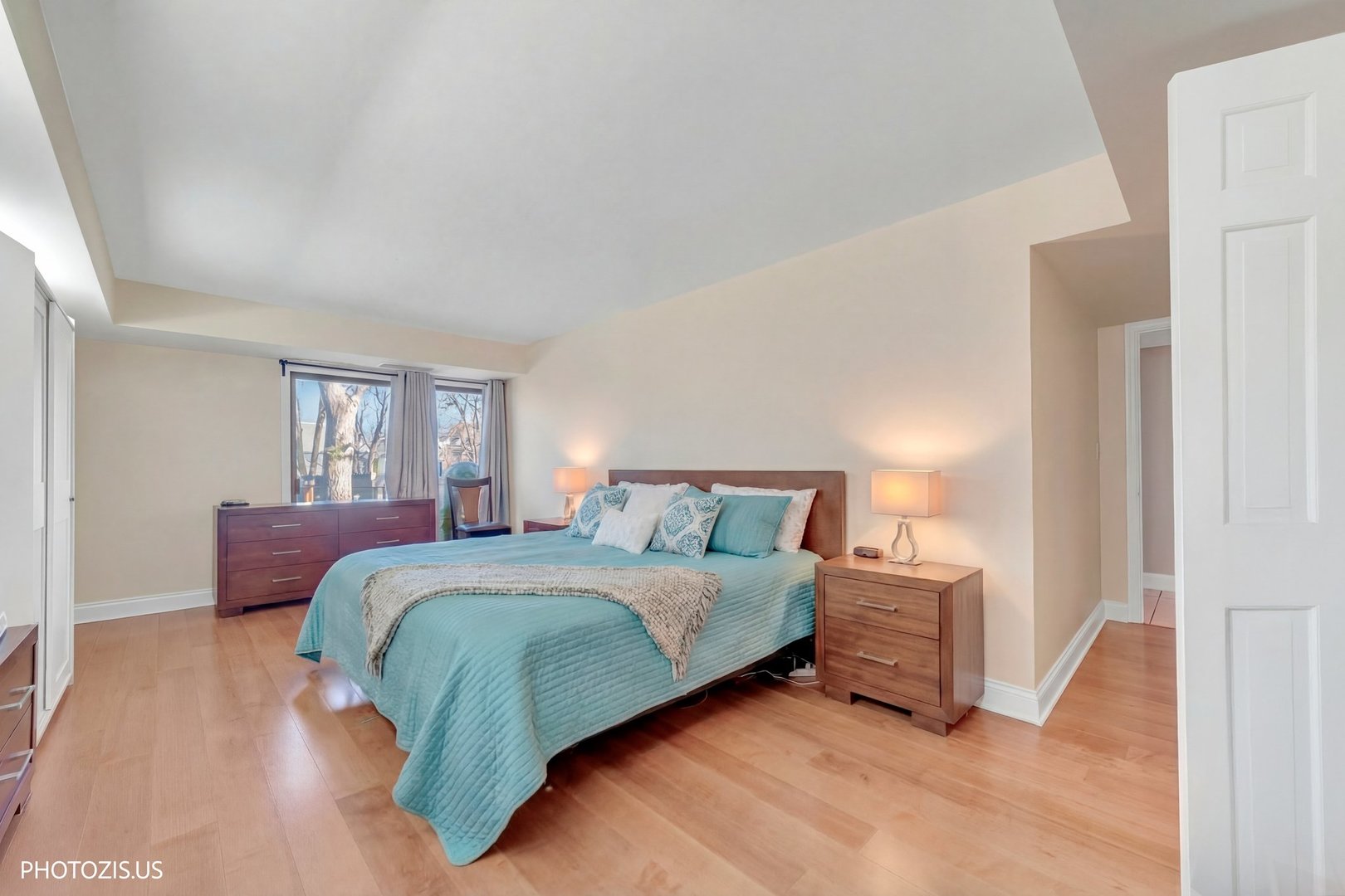 1621 Mission Hills Road, Unit 108 Northbrook, IL 60062 - Photo 12 of 22 a bedroom with a bed lamp and a dresser