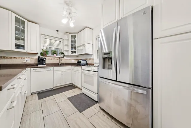 a kitchen with stainless steel appliances a sink a stove a refrigerator and cabinets
