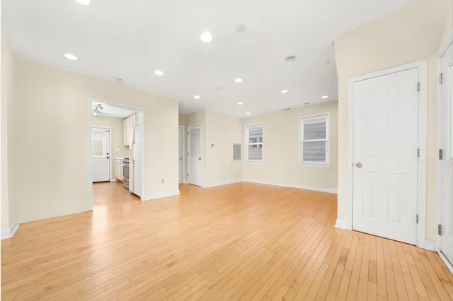 a view of empty room with wooden floor and windows