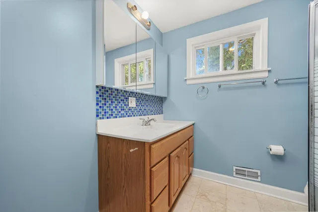 a utility room with a sink a vanity and a window