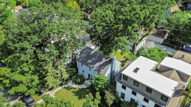 an aerial view of residential house with outdoor space and trees all around