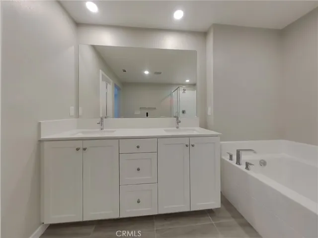 a spacious bathroom with a bathtub sink and mirror