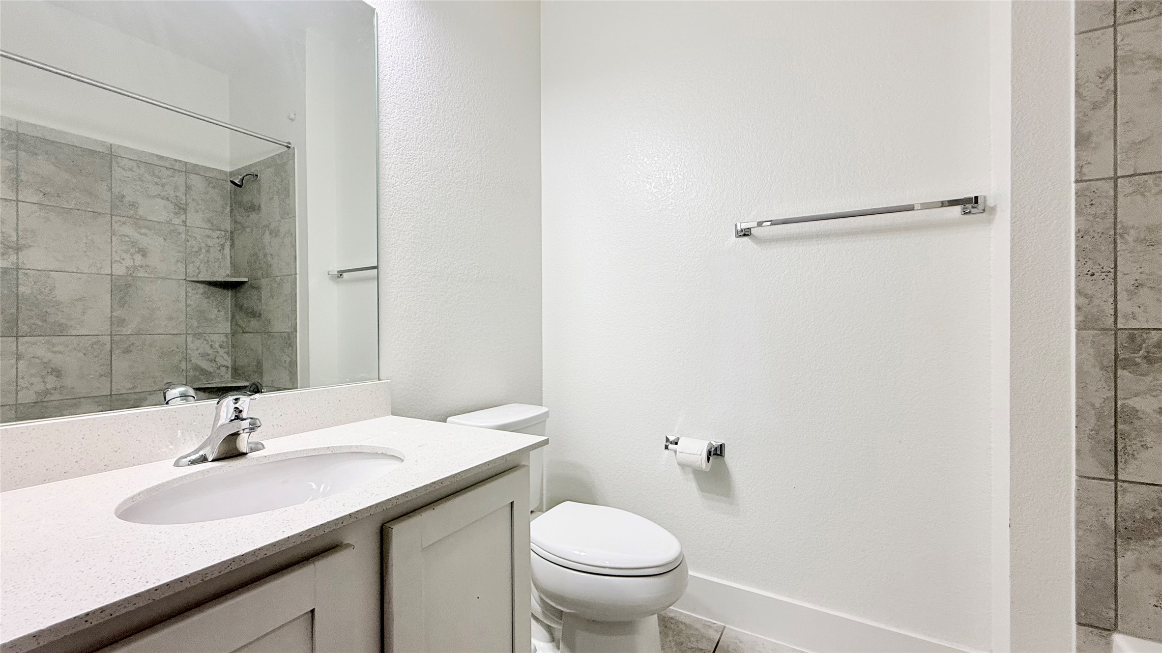600 Golden Glory Road Leander, TX 78641 - Photo 15 of 21 Full bath featuring vanity, a shower, a textured wall, and light tile patterned flooring
