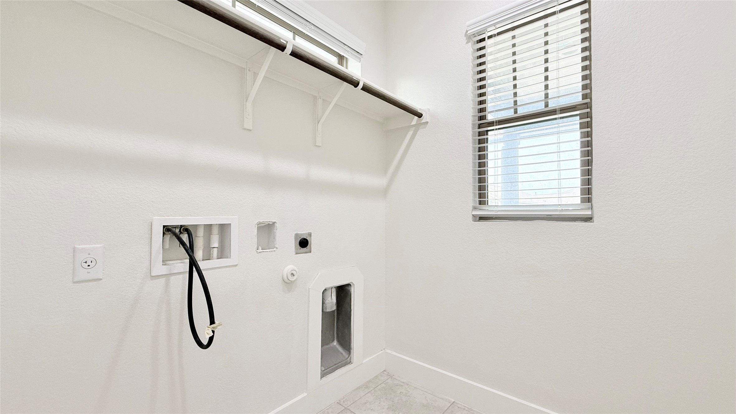 600 Golden Glory Road Leander, TX 78641 - Photo 17 of 21 Laundry room with hookup for a gas dryer, hookup for an electric dryer, washer hookup, and light tile patterned flooring