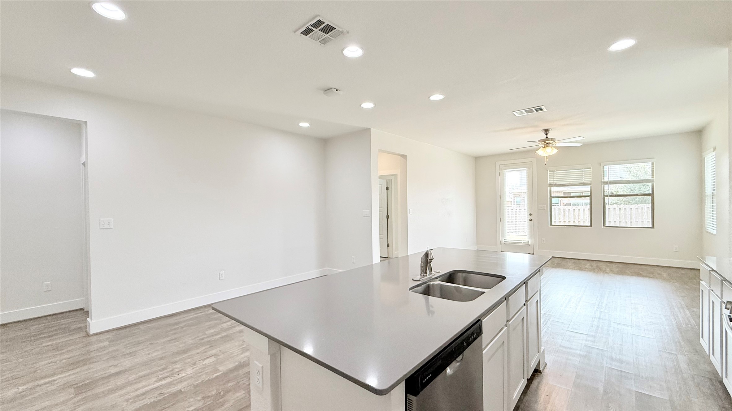 600 Golden Glory Road Leander, TX 78641 - Photo 20 of 21 Kitchen featuring recessed lighting, a center island with sink, open floor plan, light wood finished floors, and stainless steel dishwasher