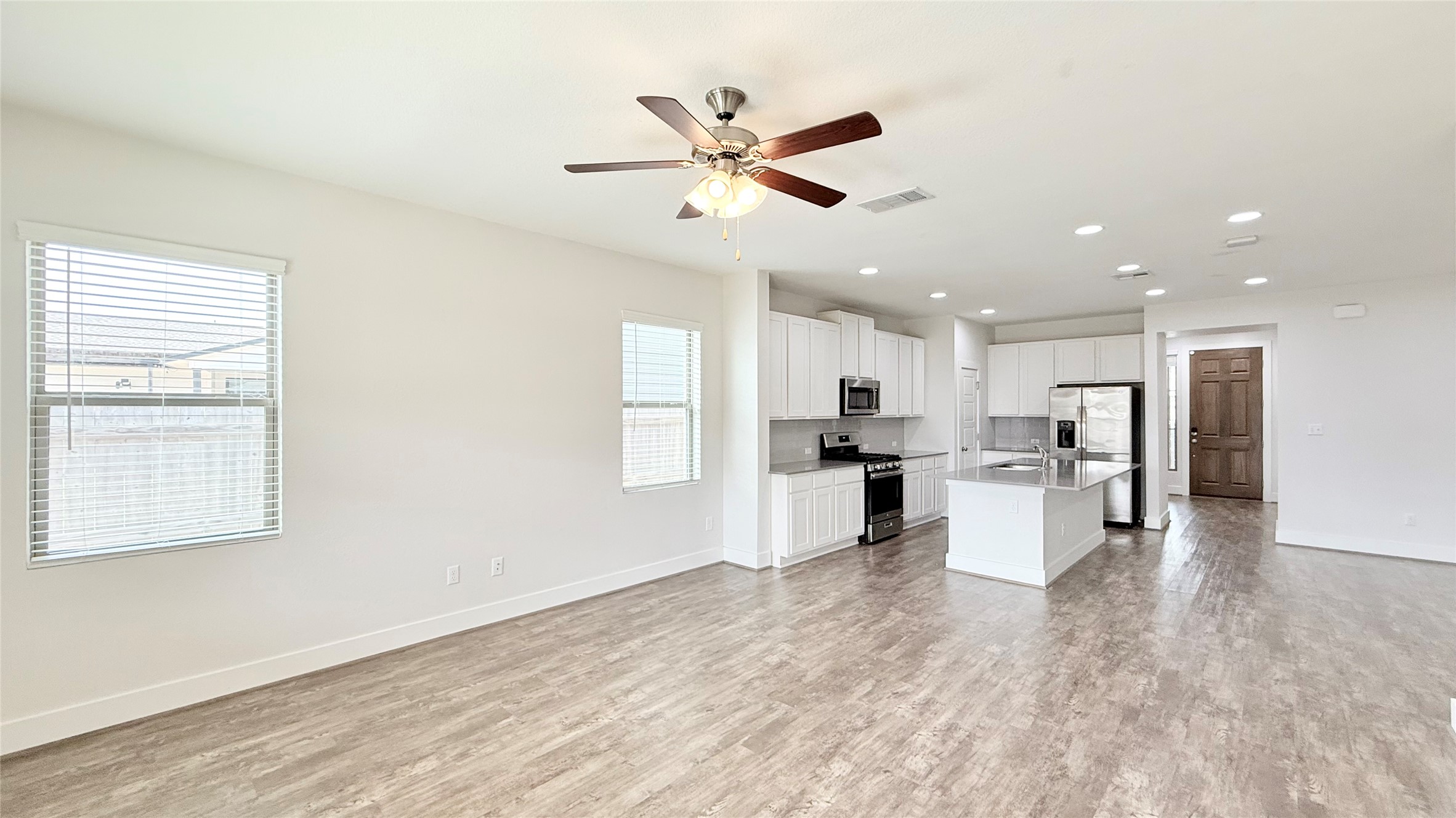 600 Golden Glory Road Leander, TX 78641 - Photo 21 of 21 Kitchen with open floor plan, white cabinets, stainless steel appliances, a center island with sink, and a ceiling fan