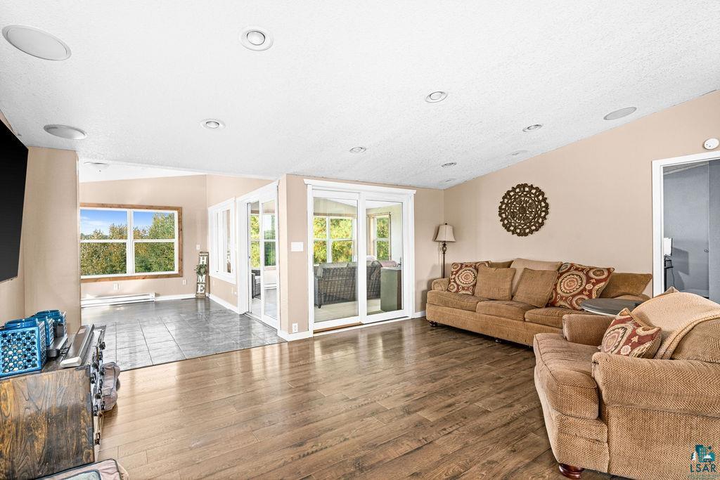 6638 Tabako Road Wright, MN 55798 - Photo 11 of 34 Living area with dark wood-type flooring, lofted ceiling, and a baseboard heating unit