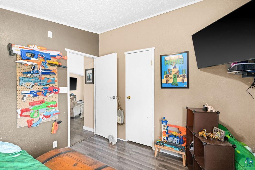 6638 Tabako Road Wright, MN 55798 - Photo 13 of 34 Bedroom featuring wood finished floors, a textured ceiling, and a textured wall