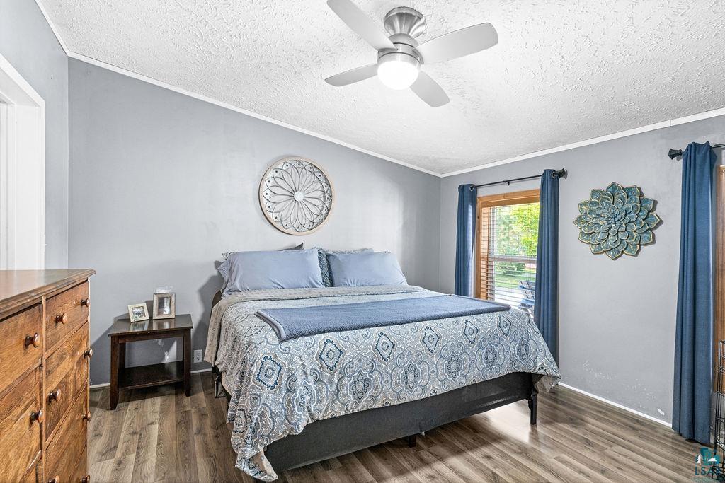 6638 Tabako Road Wright, MN 55798 - Photo 16 of 34 Bedroom featuring wood finished floors, ceiling fan, crown molding, and a textured ceiling