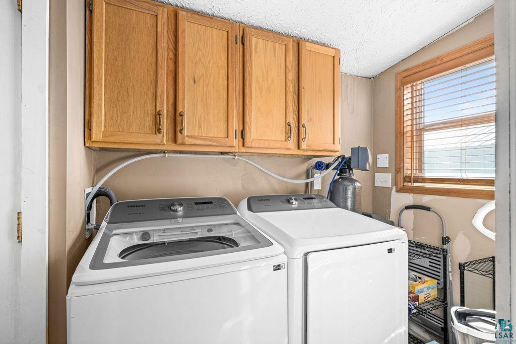6638 Tabako Road Wright, MN 55798 - Photo 21 of 34 Laundry room with cabinet space, a textured ceiling, and separate washer and dryer