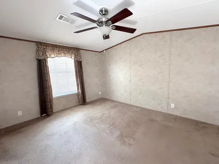 an empty room with windows and fan