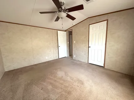 an empty room with a ceiling fan and a window