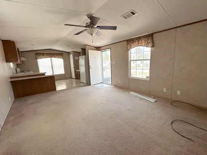a view of a livingroom with a ceiling fan and window