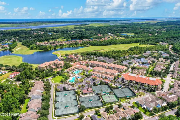 an aerial view of residential houses with outdoor space and river
