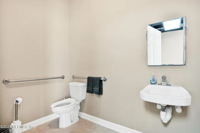 a bathroom with a toilet a sink and mirror