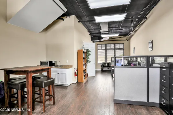 a living room with a dining table wooden floor and a window