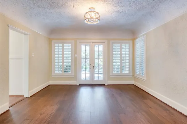 an empty room with wooden floor and a window