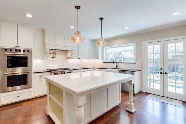 a kitchen with kitchen island a stove a sink a center island and wooden floor