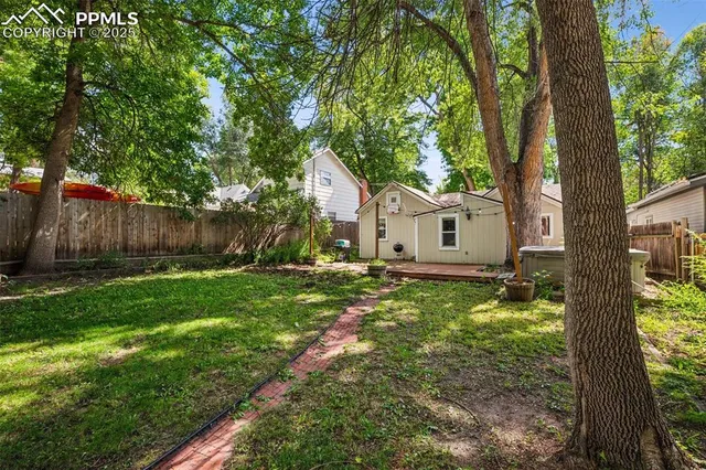 a view of a house with backyard and a tree