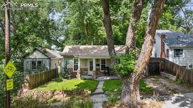 a view of a patio with table and chairs potted plants and large tree