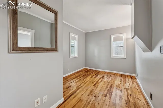 a view of empty room with wooden floor