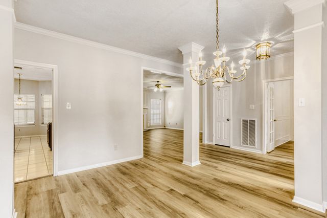 a view of a chandelier in a room with wooden floor and a bathroom