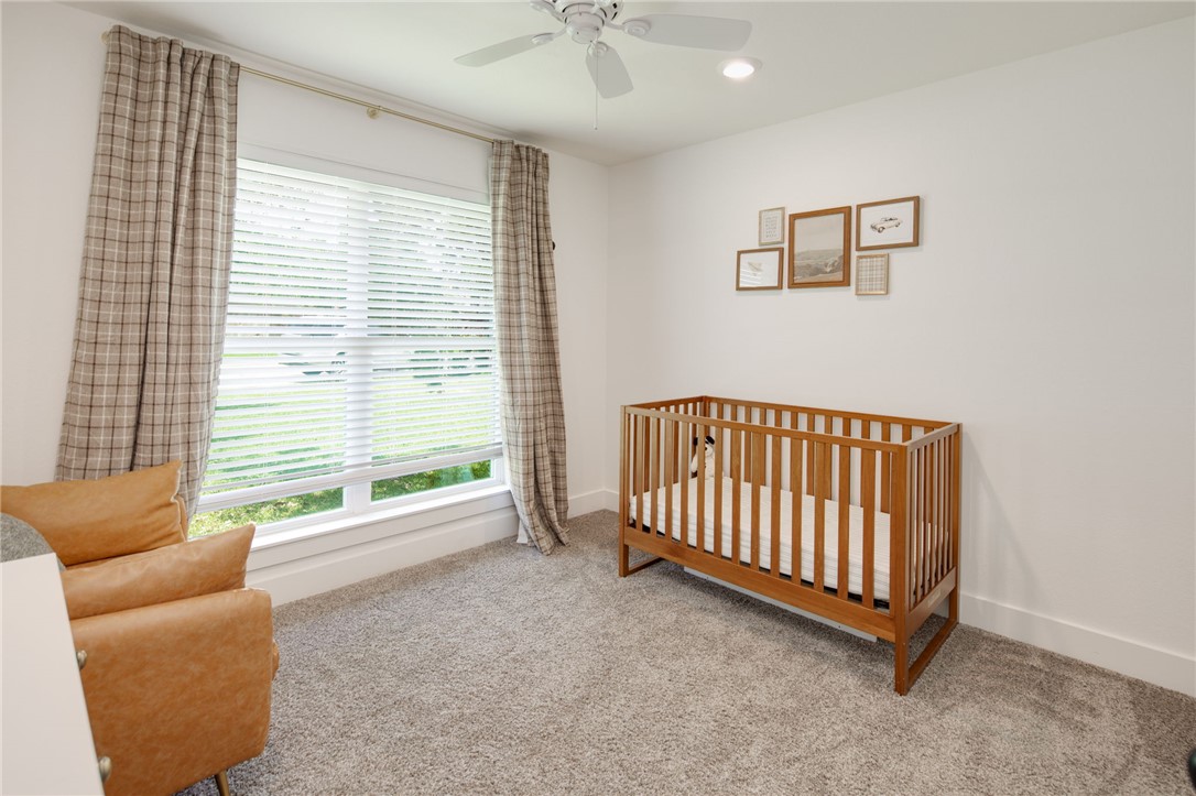 4700 Kensington Road Bryan, TX 77802 - Photo 19 of 31 Spacious room featuring a large window with blinds and patterned drapes, recessed lighting, a ceiling fan, and plush carpet flooring