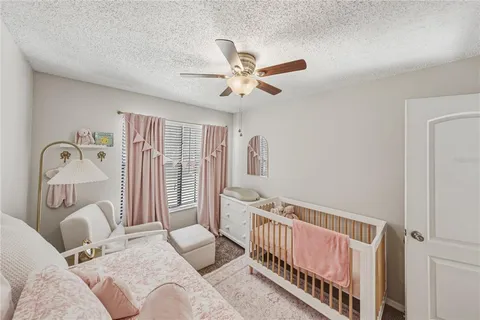 a bedroom with a bed flat screen tv and a chandelier