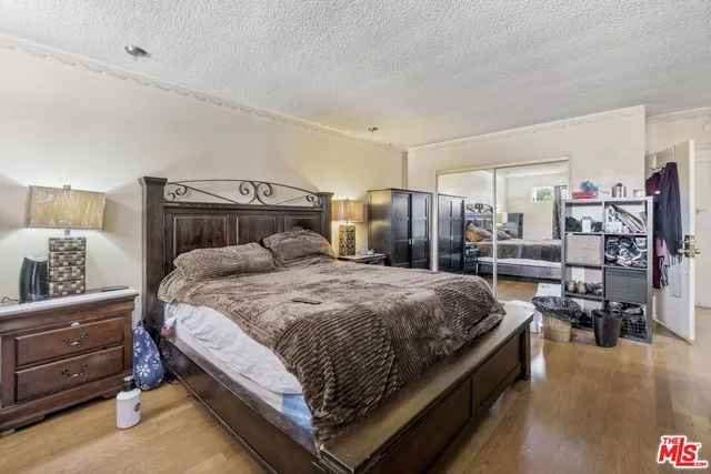 a bedroom with a bed and wooden floor