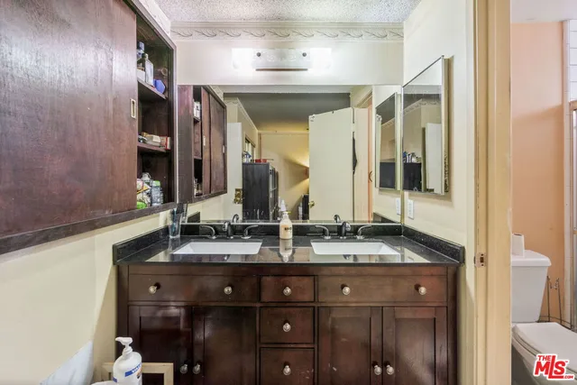 a bathroom with a granite countertop sink and a mirror