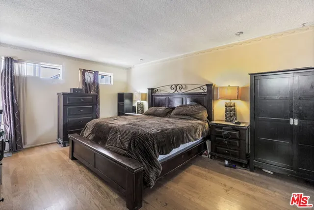 a spacious bedroom with a bed and dresser