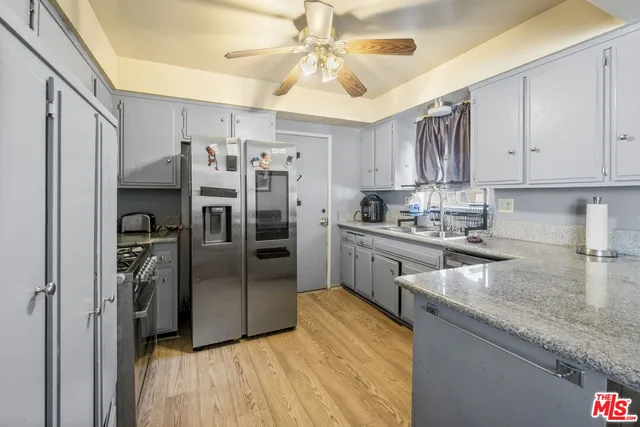 a kitchen with stainless steel appliances granite countertop a refrigerator a stove and a sink with cabinets