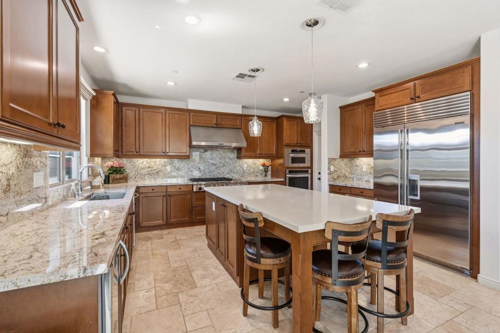 809 Dolphin Circle Encinitas, CA 92024 - Photo 31 of 71 a large kitchen with kitchen island granite countertop a stove a sink a oven and a refrigerator