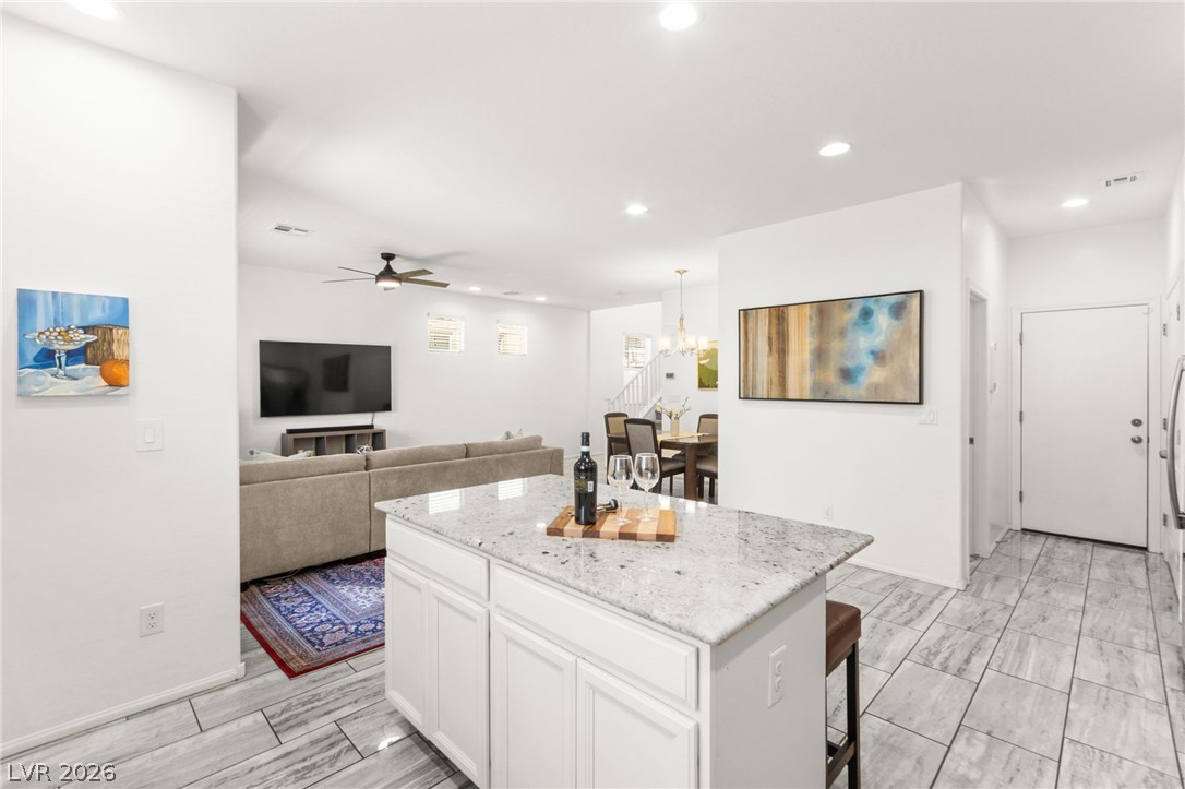 6435 Point Isabel Way Las Vegas, NV 89122 - Photo 14 of 57 A bright open-concept living space features a spacious kitchen island and tiled flooring throughout.