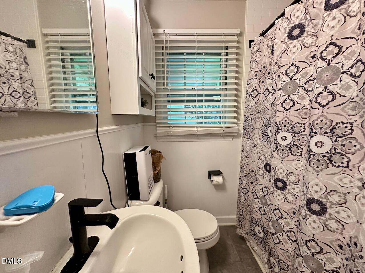 2813 Barmettler Street Raleigh, NC 27607 - Photo 18 of 22 a bathroom with a toilet and a shower curtain