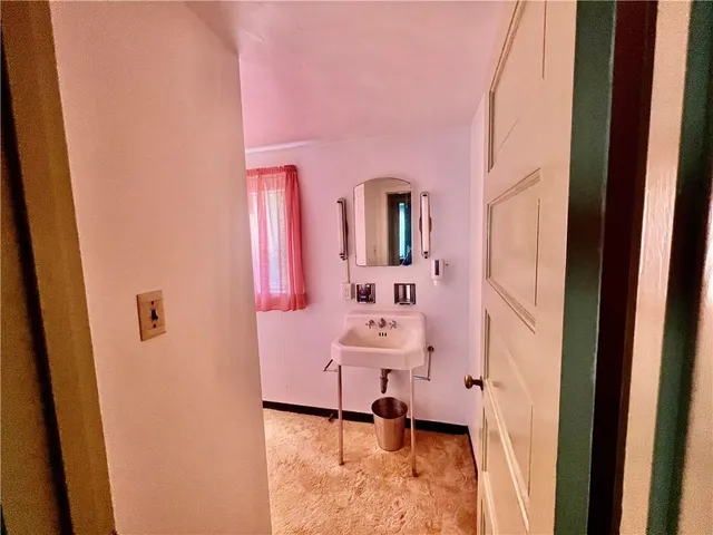 a bathroom with a sink toilet and mirror