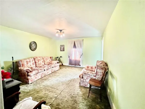 a large living room with couches and painting on the wall