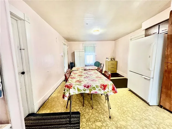 a bedroom with a bed and a refrigerator