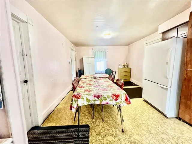 a bedroom with a bed and a refrigerator