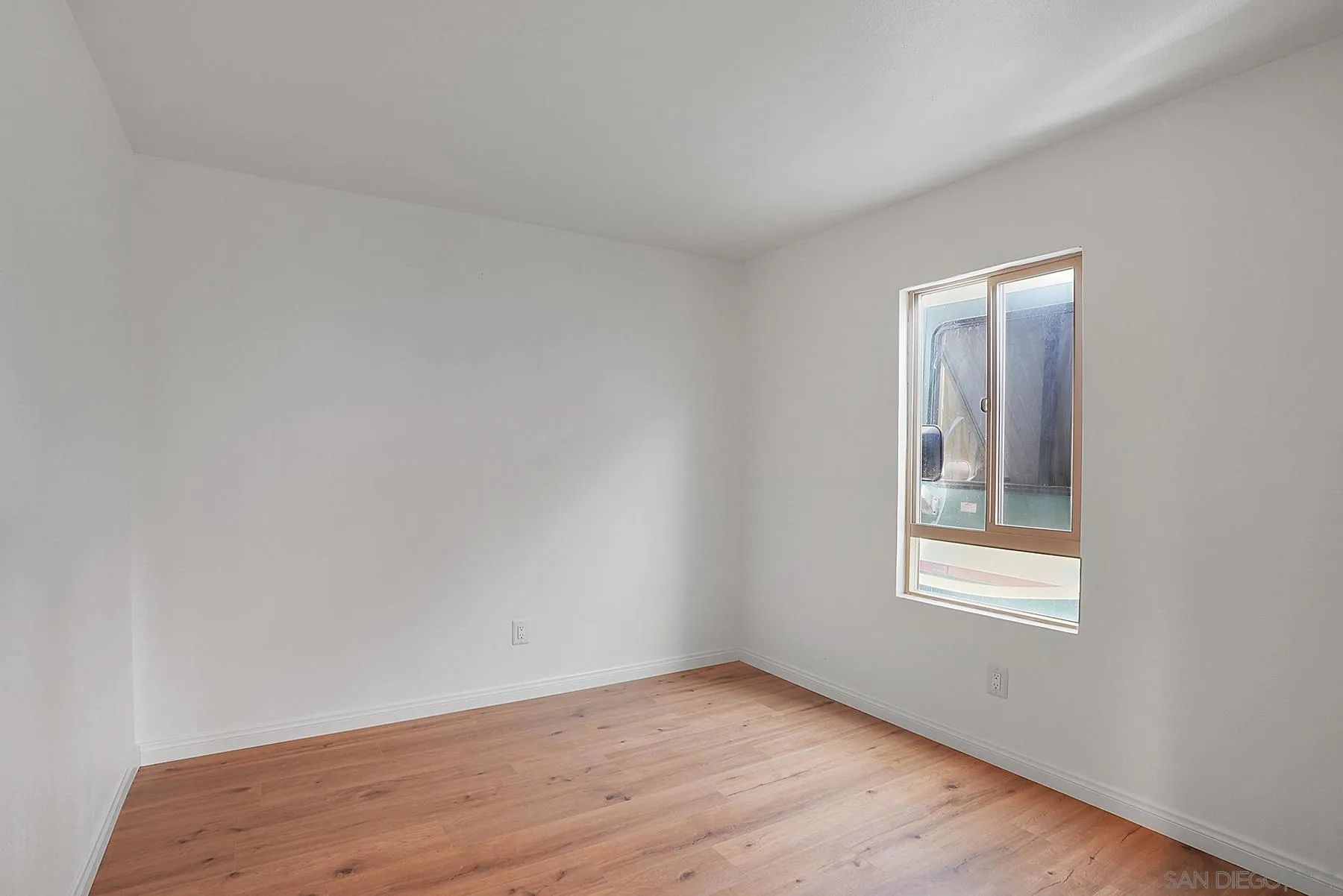 9820 St George Street Spring Valley, CA 91977 - Photo 14 of 23 a view of an empty room with wooden floor and a window