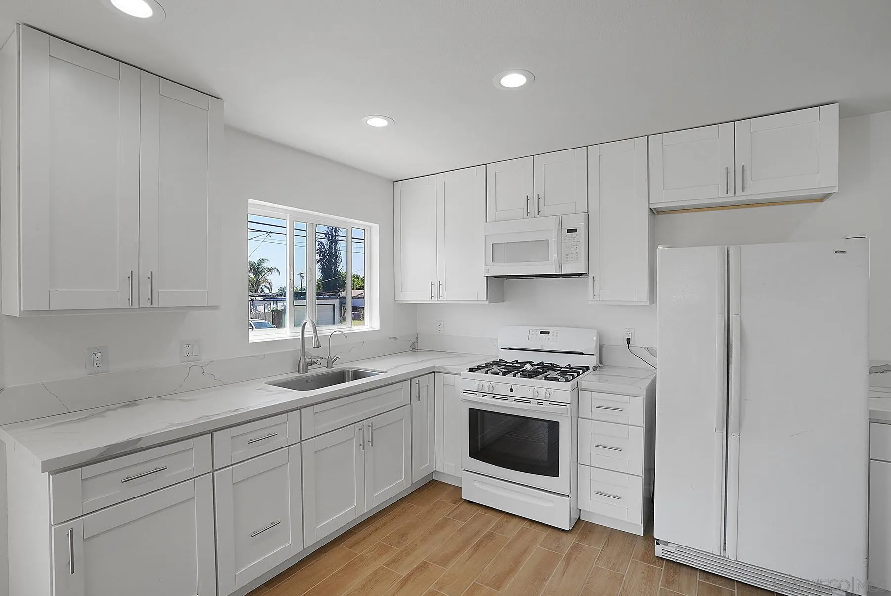 9820 St George Street Spring Valley, CA 91977 - Photo 5 of 23 a kitchen with white cabinets white stainless steel appliances and sink