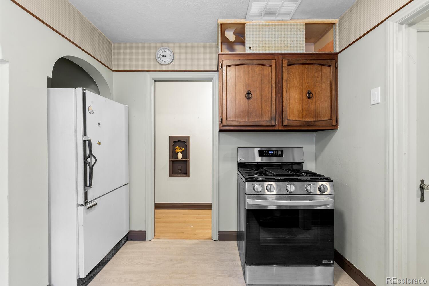 390 Dexter Street Denver, CO 80220 - Photo 16 of 30 a kitchen with stainless steel appliances a stove a refrigerator and cabinets