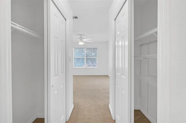 a view of a hallway with wooden floor and front door