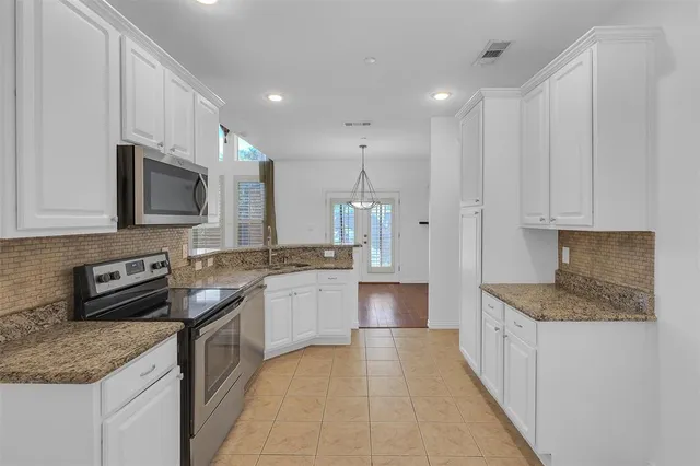 a kitchen with stainless steel appliances granite countertop a sink stove and cabinets