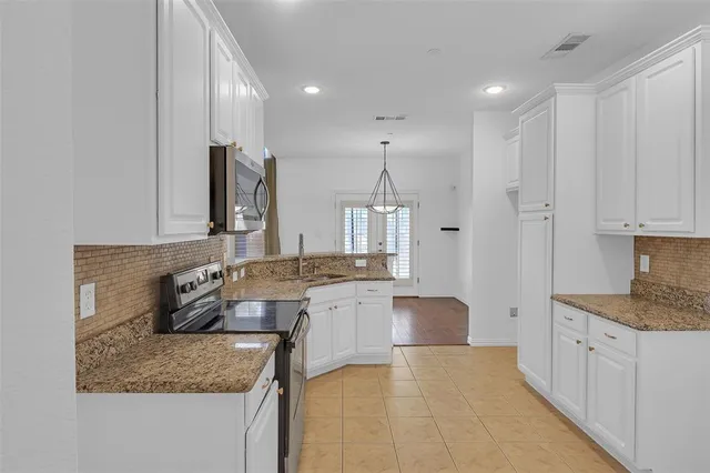 a kitchen with stainless steel appliances granite countertop a sink stove and cabinets