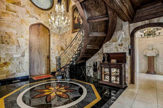 a living room with furniture chandelier and a large mirror